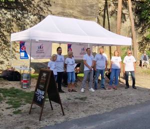 Kandidáti sdružení Za lepší Slatiňany před stanem s logem, vedle tabule zvoucí na koncert